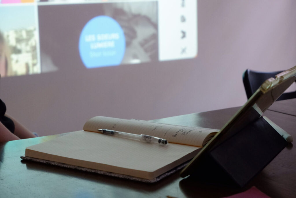 Carnet de notes et tablette pendant la présentation des contenus projetés