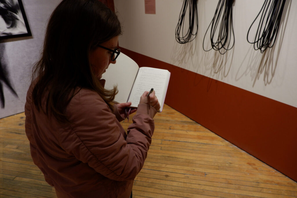 Dyana Ouvrard writing in a notebook during the evening workshop.