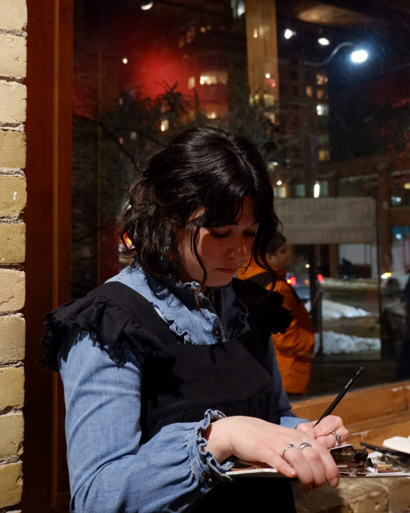 Alexane Couture taking notes in the exhibition space during the workshop.