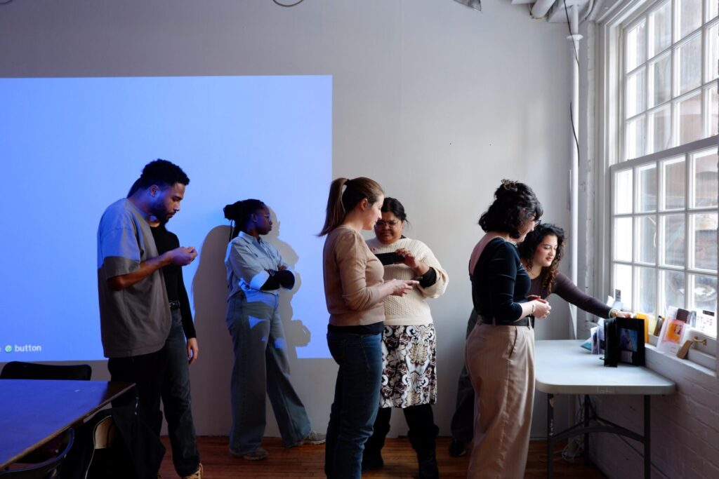 Participant.e.s observant et feuilletant des zines exposés sur une table lors de l'atelier.