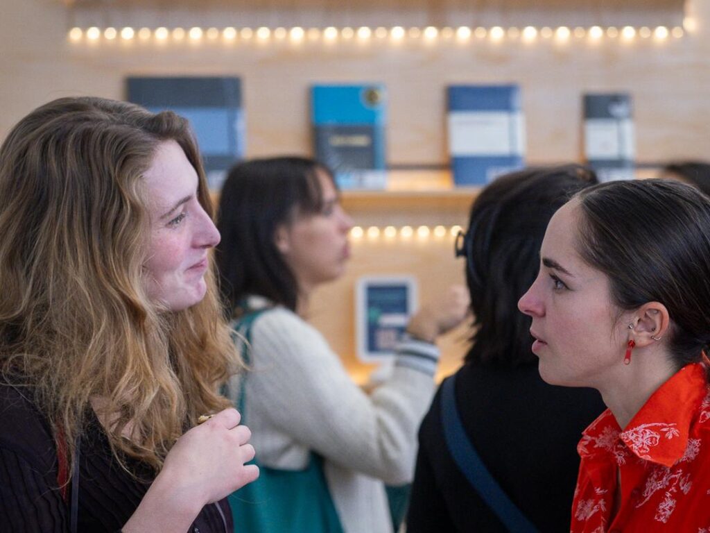 Participant·e·s rassemblé·e·s dans l’espace d’exposition, échangeant et découvrant les œuvres présentées.
