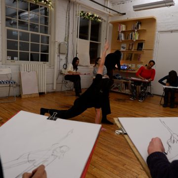 Séance de modèle vivant dans le studio d'art, participants dessinant une pose au sol.